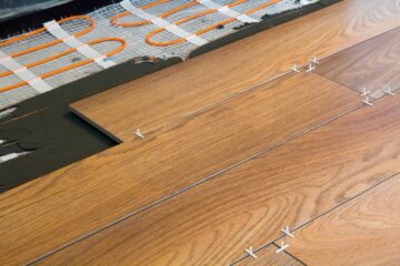 Installation of ceramic tiles and heating elements in warm tile floor. Renovation and improvement