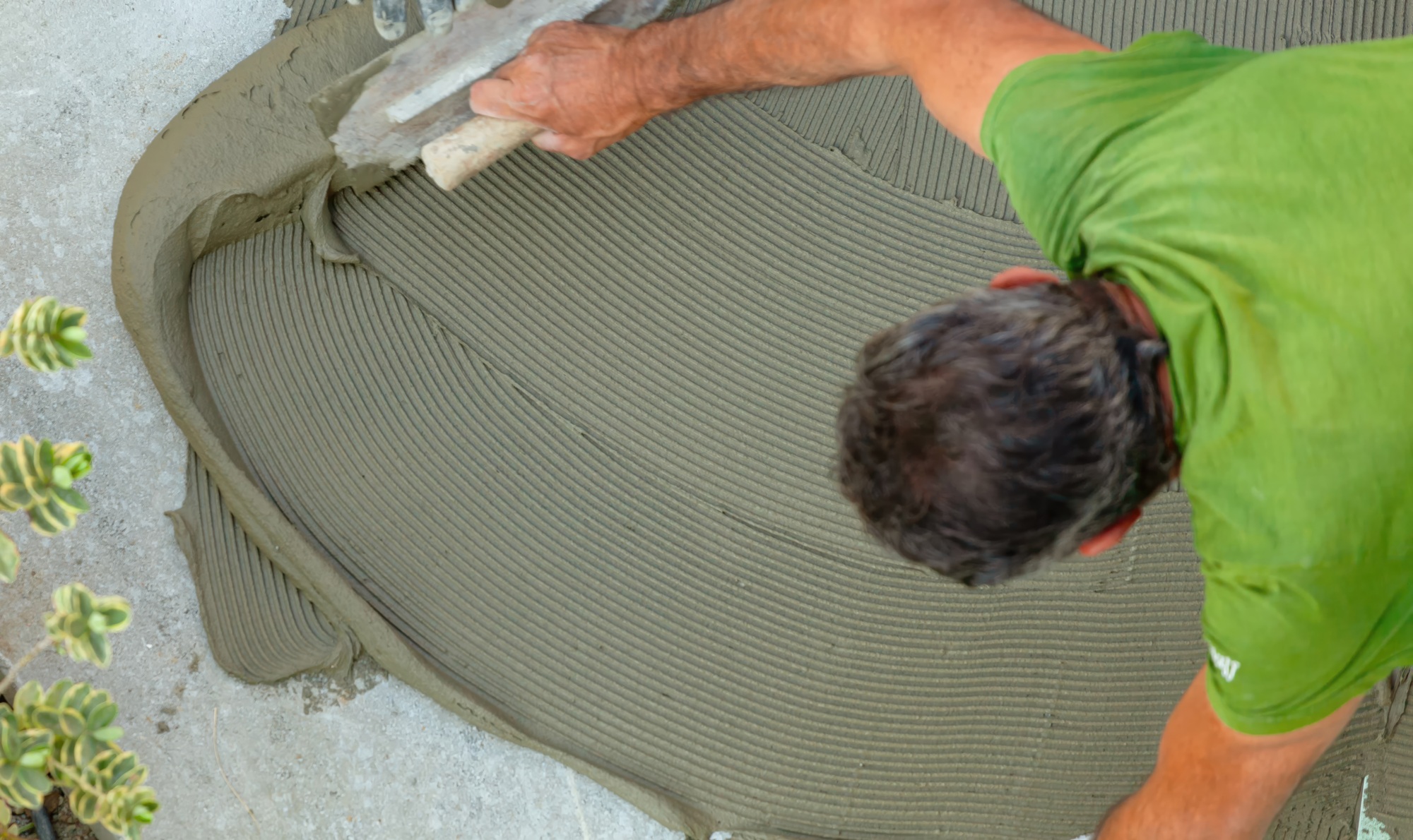 Tiler spreads glue with trowel for laying tiles.